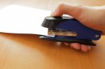 Hand Holding Blue Stapler Stapling Papers, Closeup View Stock Photo