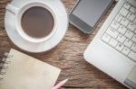 Laptop And A Cup Of Coffee With A Smartphone On Old Wooden Background. Working In The Morning Concept Stock Photo