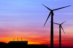 Silhouette Wind Turbine Generator With Factory Emissions Of Carb Stock Photo