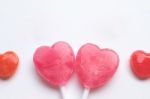 Pink Valentine's Day Heart Shape Lollipop With Small Red Candy In Cute Pattern On Empty White Paper Background. Love Concept. Colorful Hipster Style. Knolling Top View Stock Photo