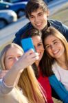 A Group Of Friends Taking Photos With A Smartphone Stock Photo