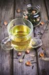 Mug Of Flavored Green Tea With Rose Buds And Petals Stock Photo