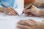 Architects Engineer Discussing At The Table With Blueprint - Clo Stock Photo