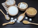 Wooden Bowl And Spoon With Sugar Cube On Dark Wood Background Stock Photo