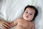 Portrait Of Newborn Baby Lying Down On A Bed, Top View Stock Photo