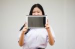 Portrait Of Thai High School Student Uniform Beautiful Girl Using Her Tablet Stock Photo