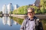 Elderly Man Resting On A River Bank Stock Photo