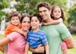 Caucasian Parents Piggyback Their Children Stock Photo