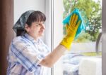 Woman Cleaning A Window With A Rag Stock Photo