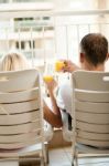 Couple On Balcony Drinking Juice Stock Photo