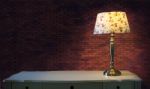 Big Brick Wall And Light Lamp On White Table Stock Photo