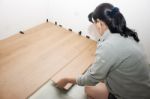 Young Woman Puts Laminate Flooring Stock Photo