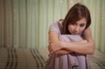 Sad Woman Sitting On The Bed Stock Photo