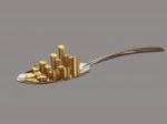 Gold Coins On A Silver Spoon Stock Photo