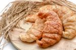 Delicious Fresh Croissants With Rice On Wooden Background Stock Photo