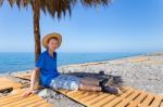 Dutch Boy Sitting Under Parasol On Portuguese Beach Stock Photo