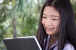 Portrait Of Thai Student Teen Beautiful Girl Using Her Tablet Stock Photo