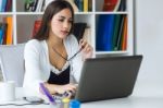 Pretty Young Woman Working With Laptop In Her Office Stock Photo