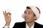 Businessman Holding Bulb And Wearing Santacap Stock Photo