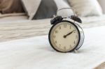 Modern Black Alarm Clock On Bed Stock Photo