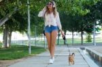 Beautiful Young Woman Walking With Her Dog In The Park Stock Photo