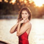 Beautiful Young Woman In The Gardens Wearing A Long Silk Red Dress Stock Photo