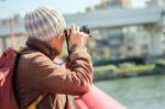 Tourist Man Taking Photo At The Bridge Under Sun Light Stock Photo