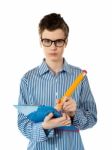 Serious Young Boy Writing On A Clipboard Stock Photo