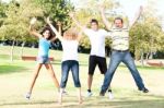 Family Jumping High In The Air On A Green Meadow Stock Photo