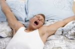 Yawning Man Stretching His Arms Stock Photo