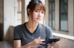 Portrait Of Thai Adult Beautiful Girl Using Her Tablet Stock Photo