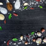 Top View Of Food Ingredients And Condiment On The Table, Ingredients And Seasoning On Dark Wooden Floor Stock Photo