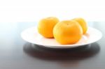 Three Orange Dish On Wooden Table Stock Photo