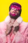 Man In A Pink Fur Coat And Carnival Glasses Stock Photo