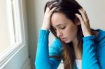 Depressed Young Woman Sitting At Home Stock Photo