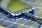 Charging Mobile Phone With Solar Charger Stock Photo