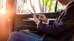 Young Handsome Businessman Working In Back Of Car And Using A Ta Stock Photo