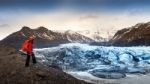 Professional Photographer With Camera And Tripod In Winter. Professional Photographer Looking To Glacier In Iceland Stock Photo