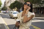 Young Woman With Coffee Laughs Into Phone Stock Photo