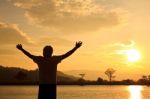 Silhouette Of Man With Hands Raised Stock Photo