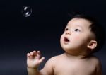 Little Baby Asian Boy Drooling And Looking Soap Bubble Stock Photo