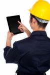 Back Pose Of Worker Operating Tablet Device Stock Photo