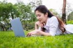 Young Woman Using Laptop In Park Stock Photo