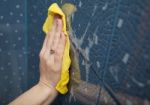 Female Hand Washes The Blue Tile On The Wall Stock Photo