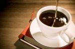 Cup Of Black Coffee And Book On Wooden Table Stock Photo