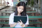 Portrait Of Thai Student Teen Beautiful Girl Using Her Tablet Stock Photo