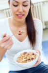 Beautiful Young Woman Eating Cereals At Home Stock Photo