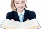 Smiling Teen Girl Looking At A Book Stock Photo