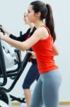 Young People With Elliptic Machine In The Gym Stock Photo