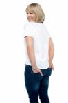 Smartly Dressed Woman With Hands In Back Pocket Of Jeans Stock Photo